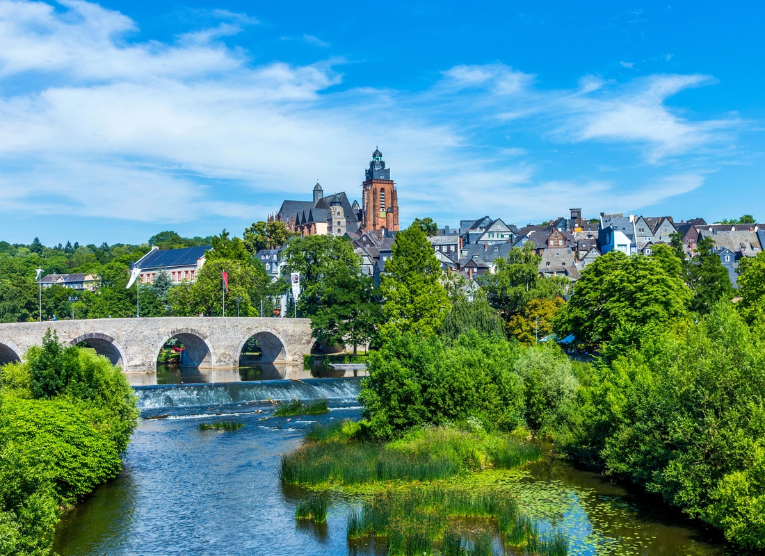 Stadtansicht von Heidelberg, mit historischen Gebäuden und der Neckarbrücke im Vordergrund.