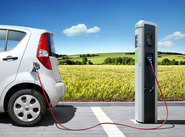 Ein Elektroauto ist an einer Ladestation für Elektrofahrzeuge angeschlossen. 