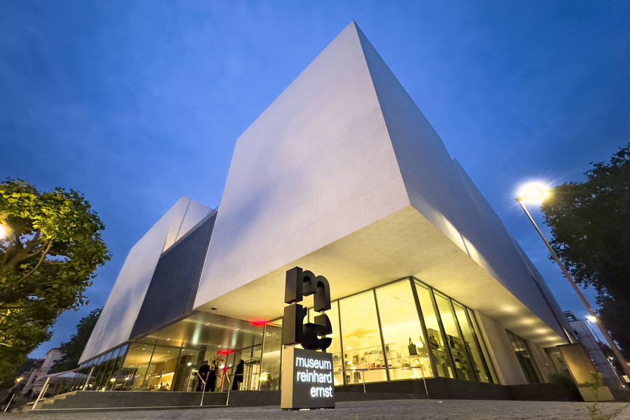 Modernes Reinhard Ernst Museum, das nachts beleuchtet ist und eine einladende Atmosphäre schafft.
